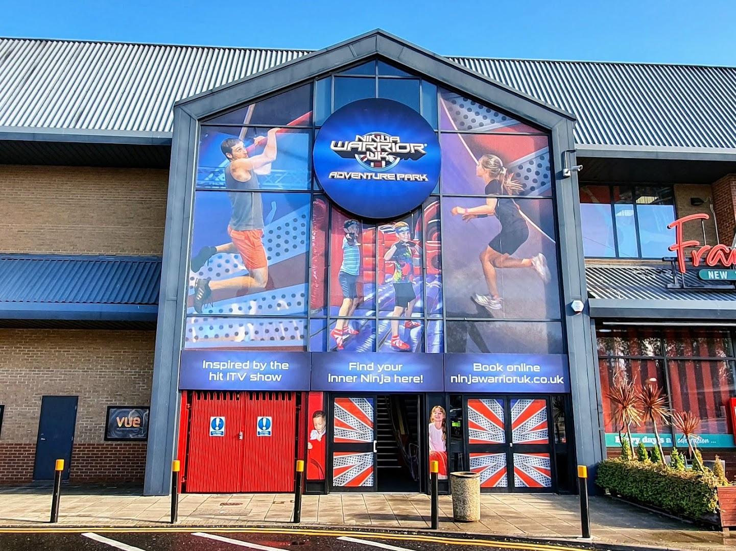 Ninja Warrior UK Watford entrance featuring vibrant graphics and adventure park activities