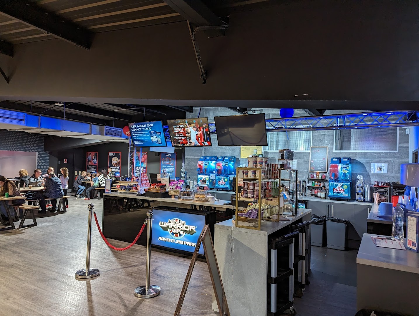 Café area at Ninja Warrior UK Watford with seating and arcade games